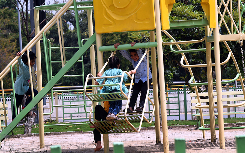 Children enjoy swings at a local park along Faisal Avenue in the Federal Capital