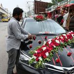 A man decorates a car with flowers for a wedding at 47 Adda