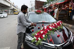 A man decorates a car with flowers for a wedding at 47 Adda