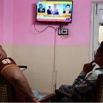 People watch television news coverage of the U.S.–Iran peace talks in Islamabad as diplomatic efforts continue in the capital amid heightened global attention