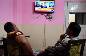 People watch television news coverage of the U.S.–Iran peace talks in Islamabad as diplomatic efforts continue in the capital amid heightened global attention