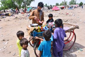 A vendor busy in selling ice Gola to children near at railway station.