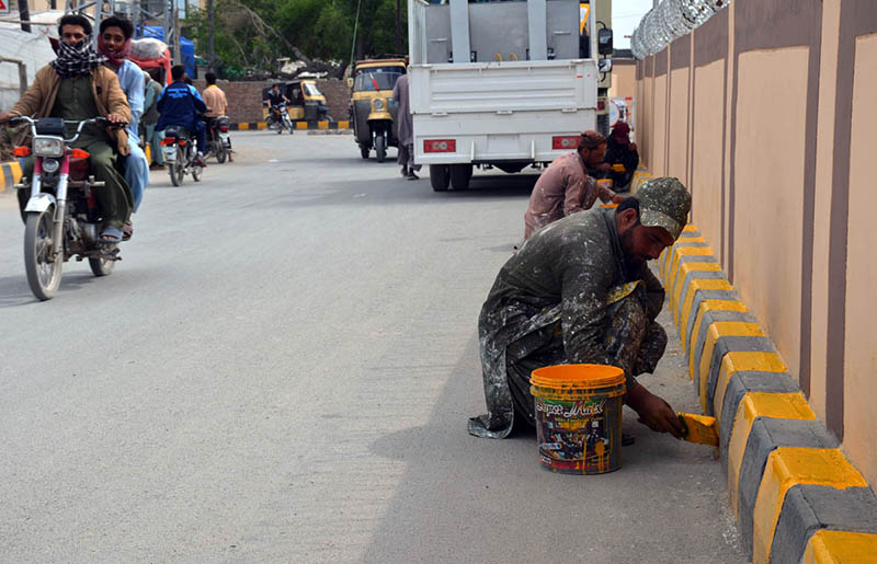 Workers are painting and marking the road divider on a newly constructed roadway linking Chaman Phatak to Koila Phatak, helping organize traffic flow and improve road safety