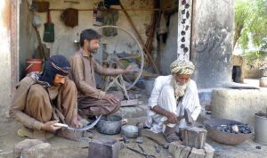 An ironsmith crafts sickles and other farming tools to help farmers in harvesting their wheat crops.
