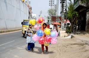 Young girls sell colorful balloons at 47 Adda, attracting passersby as they strive to support their families.