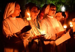 Members of the Christian community take part in their religious rituals, holding candles during the Easter prayer at St. Francis Xavier Catholic Church.
