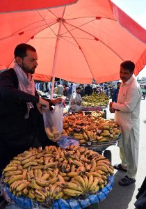 A vendor selling banana to attract customers at his roadside setup