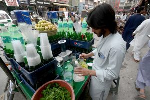 A man preparing fresh soft drink at Qissa Khawani Bazar as the temperature rises high rapidly.