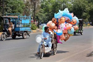 A disable vendor on the way on wheelchair displayed air filled toys to attract the customers