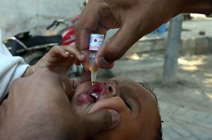 A polio worker administers drops to a child during an anti-polio drive at Dr Faisal Masood Teaching Hospital.