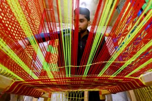 Workers busy in knitting traditional beds (Charpai) at their workplace near the Dabgari Area.