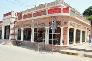 A worker stands on scaffolding while carrying out finishing and maintenance work of a historic library building during ongoing renovation on the International Labour Day.