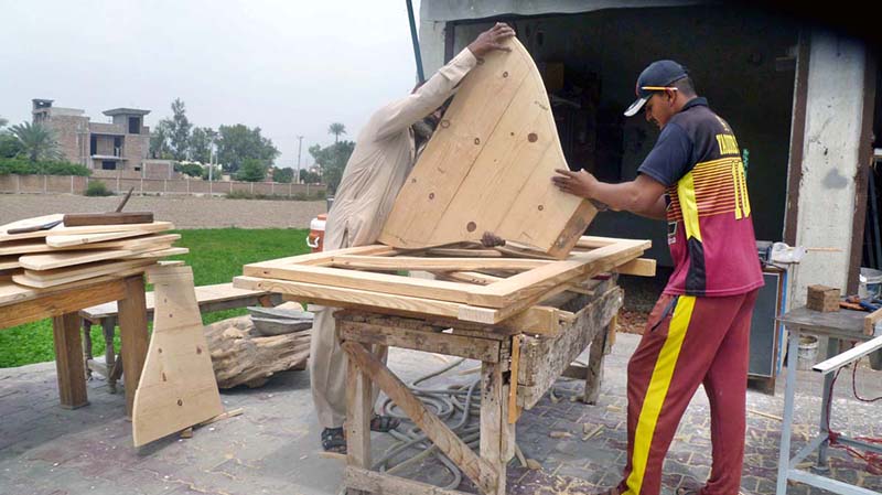 Carpenters are busy making wooden door at their workplace