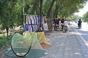 A vendor selling domestic use items at his roadside setup.