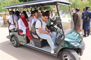 LUMHS medical students travel in an electric bus after the inauguration of a free campus transport service.