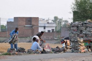 Labourers sort and stack empty cement bags collected from various points for resale and reuse on the outskirts of the city.