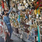 People busy selecting and purchasing decoration pieces from stall in Sunday Bazaar, Peshawar Morr