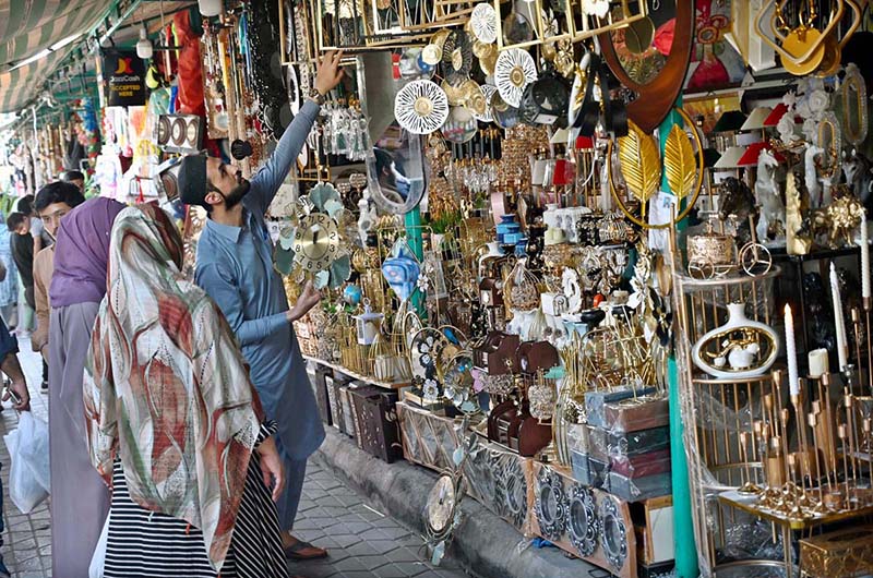 People busy selecting and purchasing decoration pieces from stall in Sunday Bazaar, Peshawar Morr