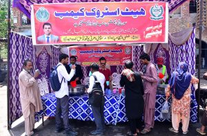 A volunteer offers cool drinking water to citizens at a heatstroke relief camp set up by the district administration at Hyder Chowk amid scorching temperatures.