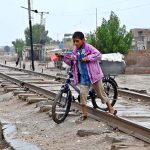 A boy along with bicycle while crossing the railway tracks near Allahbad Mohallah