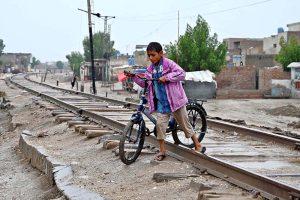 A boy along with bicycle while crossing the railway tracks near Allahbad Mohallah