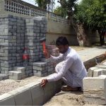 Labourers are busy installing durable tiles on a footpath as part of a city beautification and road construction project, with multiple road works currently underway across the area