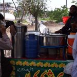 A vendor sells traditional drink (shakar cola) along the roadside to attract customers