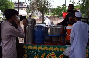 A vendor sells traditional drink (shakar cola) along the roadside to attract customers