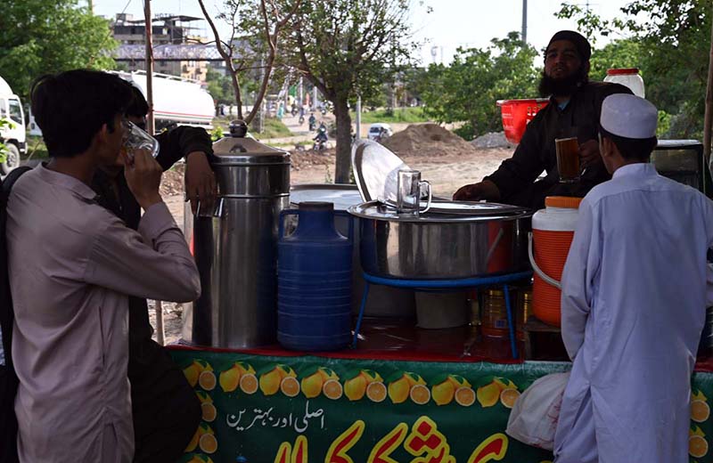 A vendor sells traditional drink (shakar cola) along the roadside to attract customers