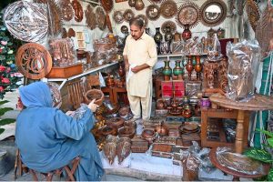 People busy selecting and purchasing decoration pieces from stall in Sunday Bazaar, Peshawar Morr