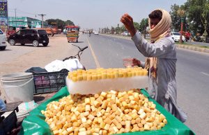 A vendor sells traditional drink (shakar cola) along the roadside to attract customers