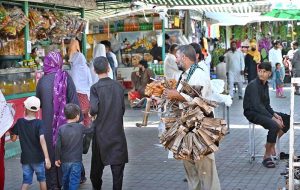 People busy selecting and purchasing decoration pieces from stall in Sunday Bazaar, Peshawar Morr