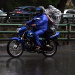 Motorcyclist covered himself with a plastic sheet to protect from rain that experienced in the Provincial Capital