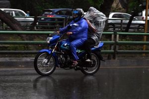 Motorcyclist covered himself with a plastic sheet to protect from rain that experienced in the Provincial Capital