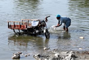A person washing his tricycle loader at the bank of Rice Canal.