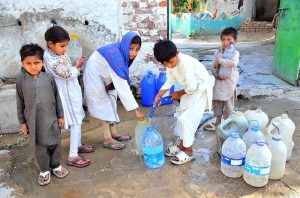 Children fill cans with clean water from a pipeline in Alam Town.