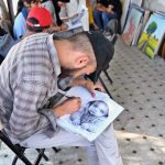 A student busy in making painting at Peshawar Mor Sunday Bazaar