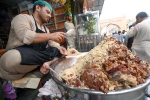 A vendor showers water on coconut to keep it fresh and attract the customers at Namak Mandi Chowk