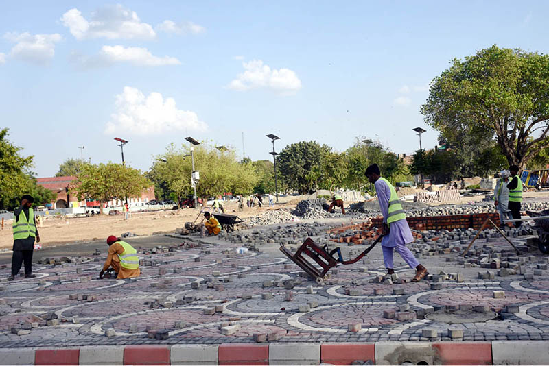 LDA workers are laying and fixing tuff tiles on a footpath as part of beautification work in the provincial capital