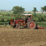 A farmer is busy ploughing and leveling a field with his tractor along Mirpurkhas Road