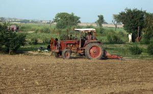 A farmer is busy ploughing and leveling a field with his tractor along Mirpurkhas Road