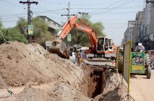 WASA workers lay a new pipeline with heavy machinery in Madina Town near Hockey Stadium.
