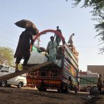 Labourers loading vegetable-filled sacks onto a delivery truck at the Vegetable Market for onward distribution across the city