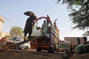Labourers loading vegetable-filled sacks onto a delivery truck at the Vegetable Market for onward distribution across the city
