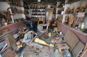 A craftsman is busy making the traditional musical instrument, Rabab, at his workshop in the Tehsil area