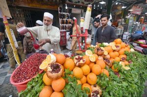 A roadside vendor preparing pomegranate juice for a customer at Qissa Khawani Bazar
