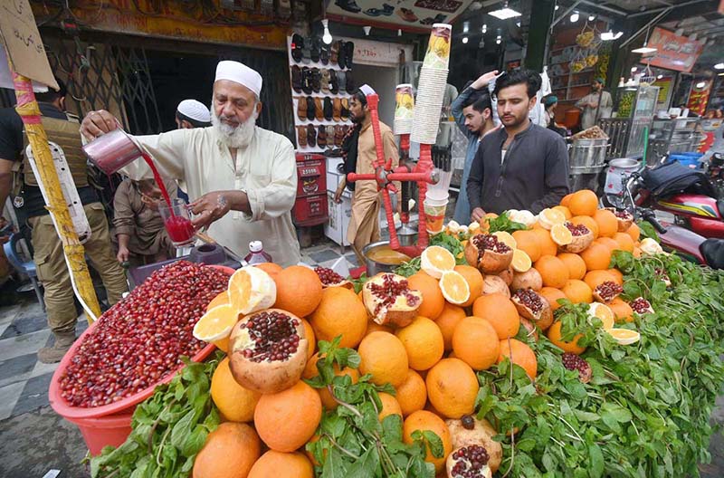 A roadside vendor preparing pomegranate juice for a customer at Qissa Khawani Bazar
