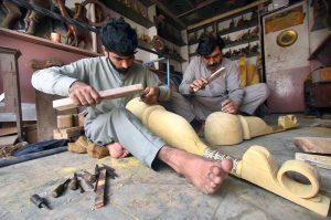 A craftsman is busy making the traditional musical instrument, Rabab, at his workshop in the Tehsil area