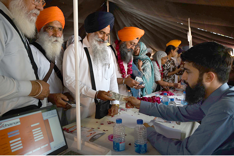 Indian Sikh yatrees exchanging money after arrive at wagha border as Thousands of Indian Sikh pilgrims (yatrees) arrived at the Wagah Border to celebrate the Vaisakhi Mela and the 327th birth anniversary of the Khalsa