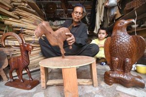 A craftsman is busy making the traditional musical instrument, Rabab, at his workshop in the Tehsil area